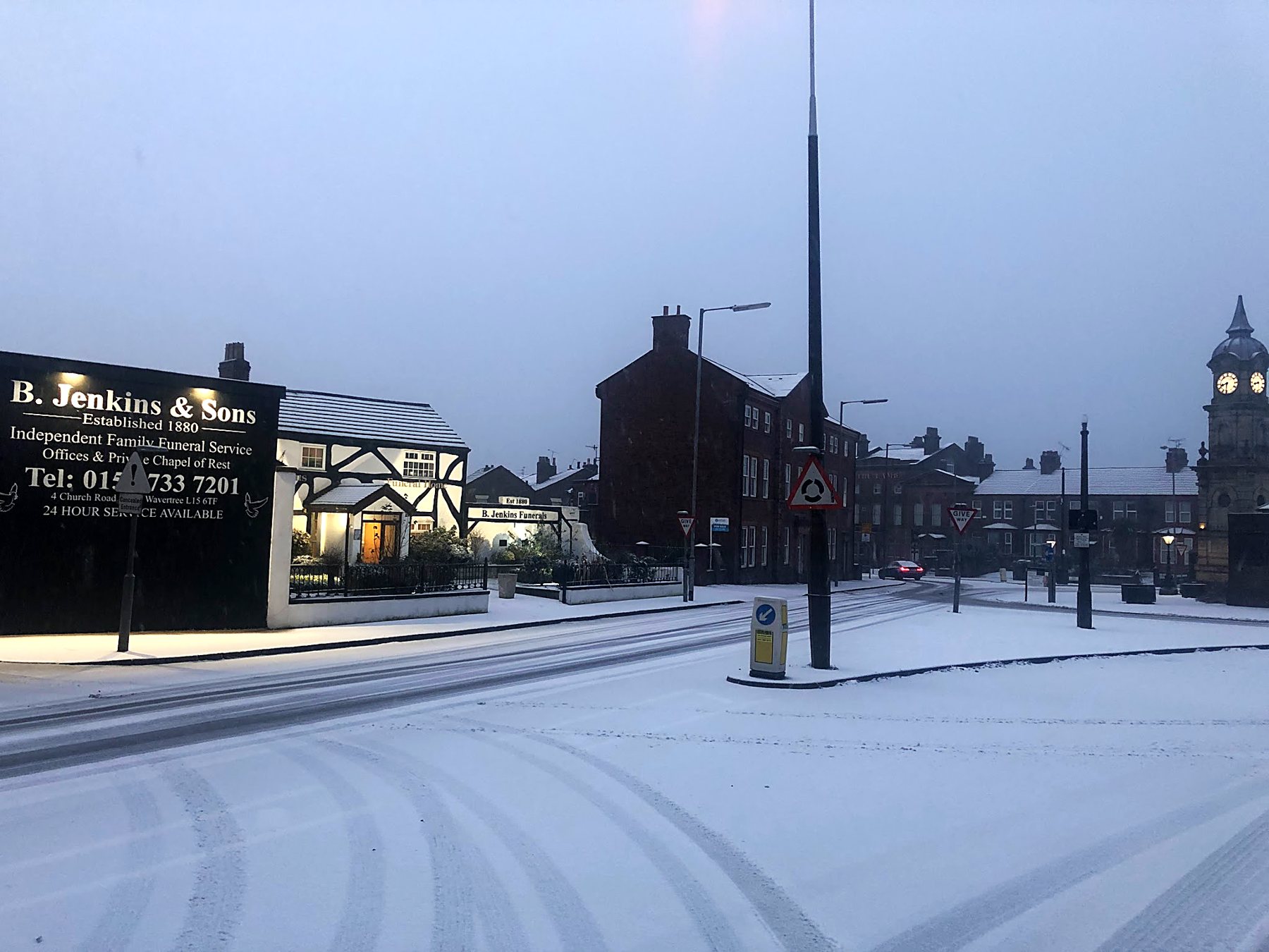 The roadside sign in snow, with the Picton Clock beyond