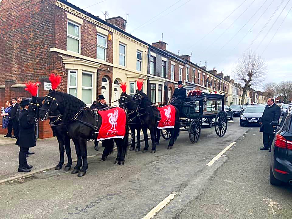Shire horses in club colours drawing the glass carriage