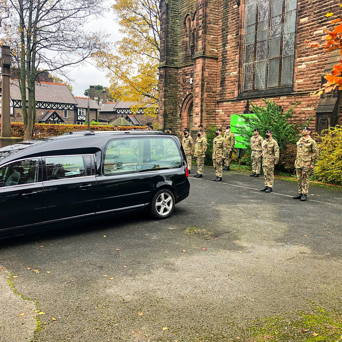 A military guard of honour beside the hearse at a church
