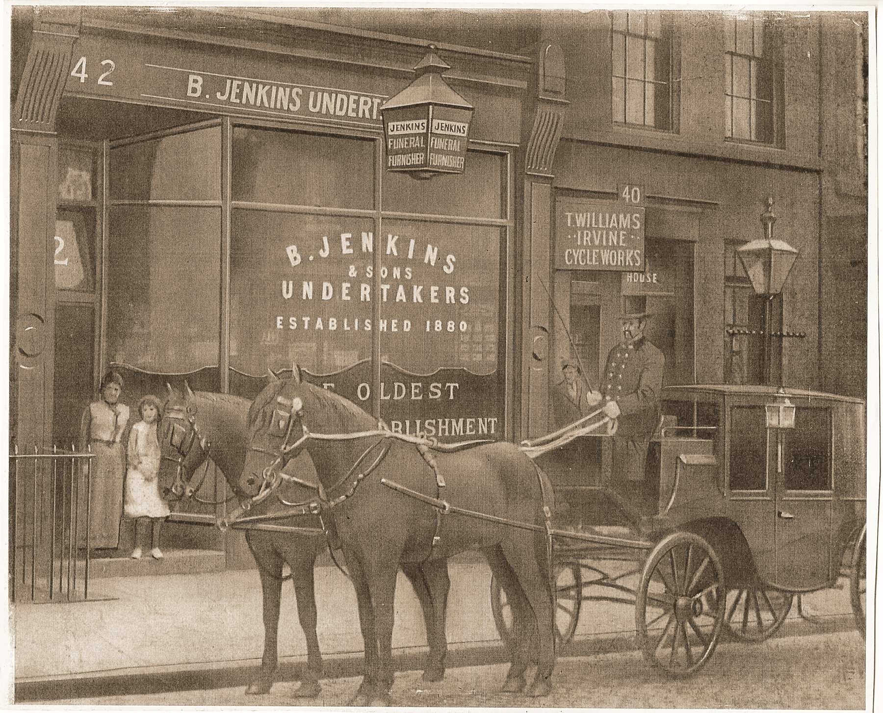 Archive photograph of the original B. Jenkins & Sons shop on Irvine Street, Liverpool, with a horse-drawn hearse outside